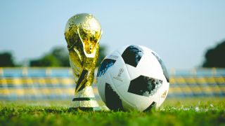 World Cup Trophy Sitting next to a soccer ball