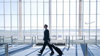 Man with suitcase walking through airport